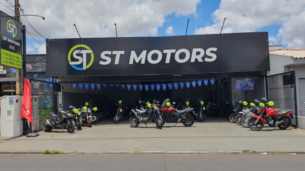 Fachada preta com o logotipo da ST Motors. Motos com bexigas abaixo.