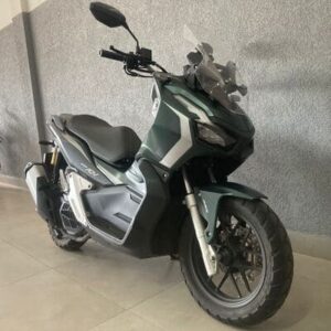 Moto Honda Adv 150 abs 2024, verde. Moto de frente na diagonal para a diretira.